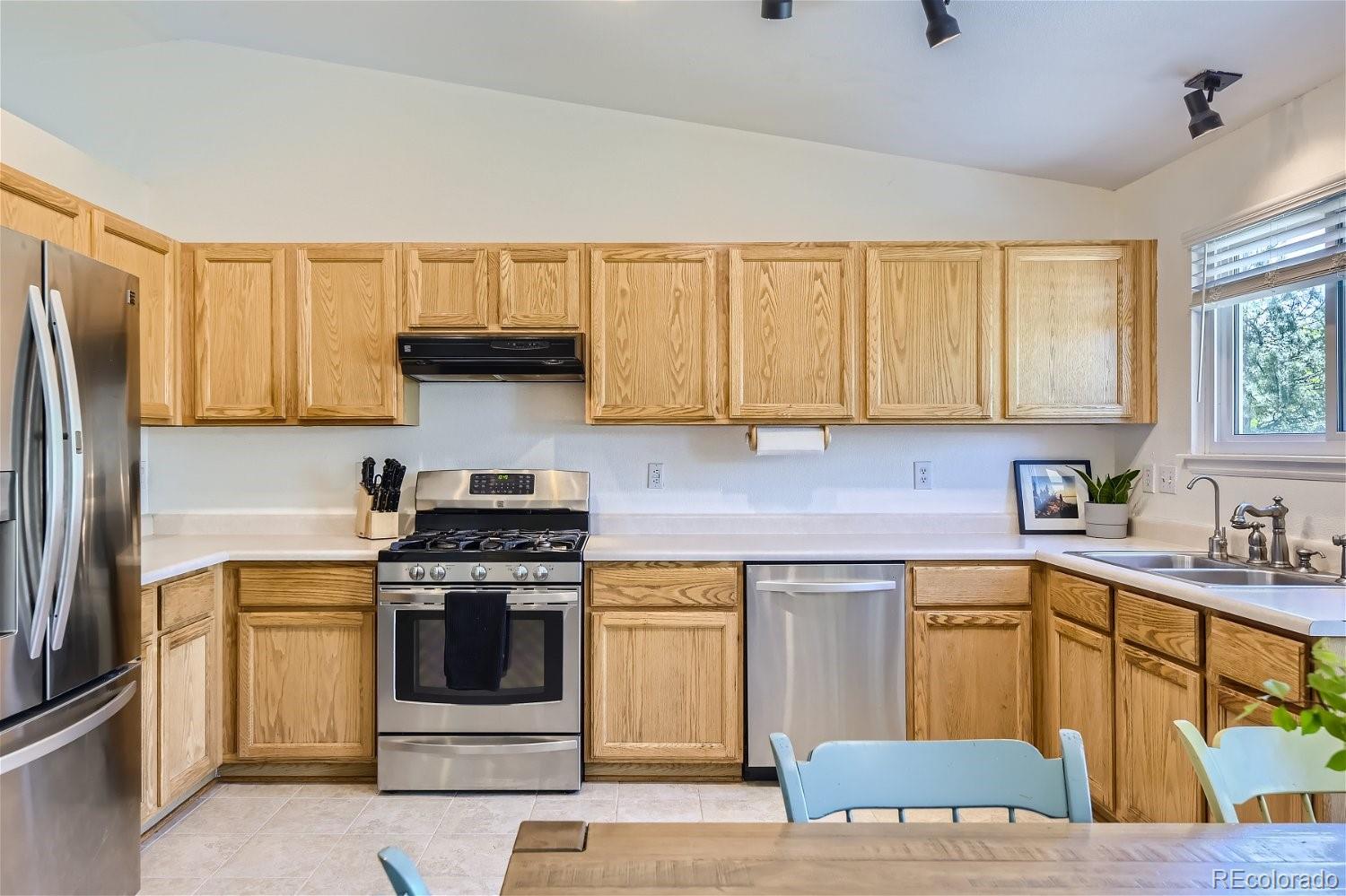 9744 South Castle Ridge Circle Highlands Ranch, CO 80129 - Photo 15 of 28 a kitchen with a stove a sink and a refrigerator