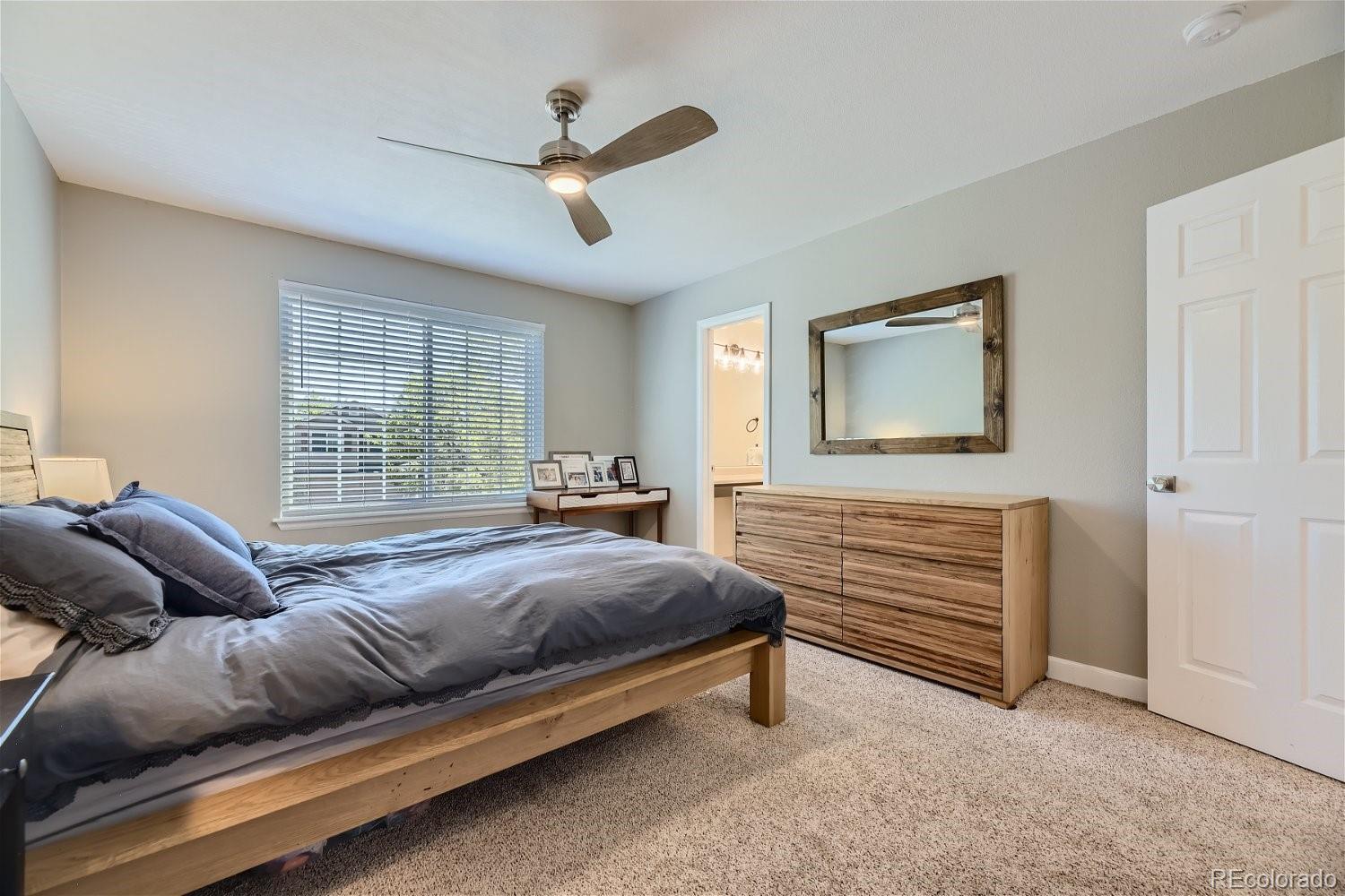 9744 South Castle Ridge Circle Highlands Ranch, CO 80129 - Photo 17 of 28 a spacious bedroom with a bed and window
