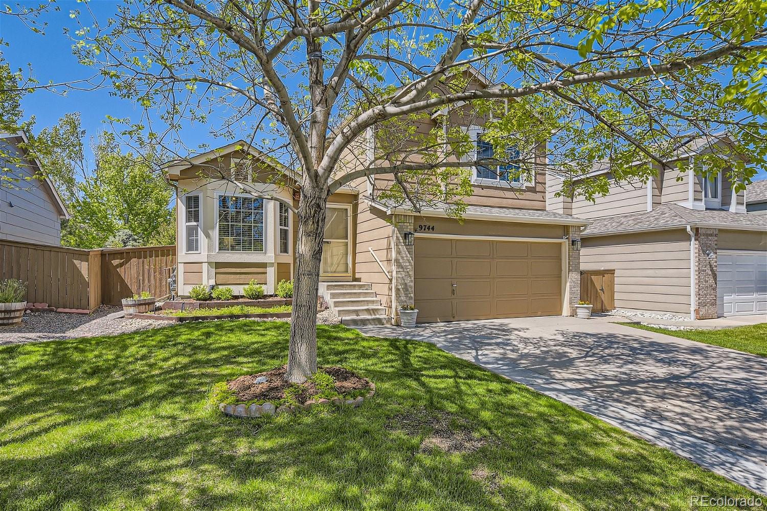 9744 South Castle Ridge Circle Highlands Ranch, CO 80129 - Photo 2 of 28 a front view of a house with a yard and garage