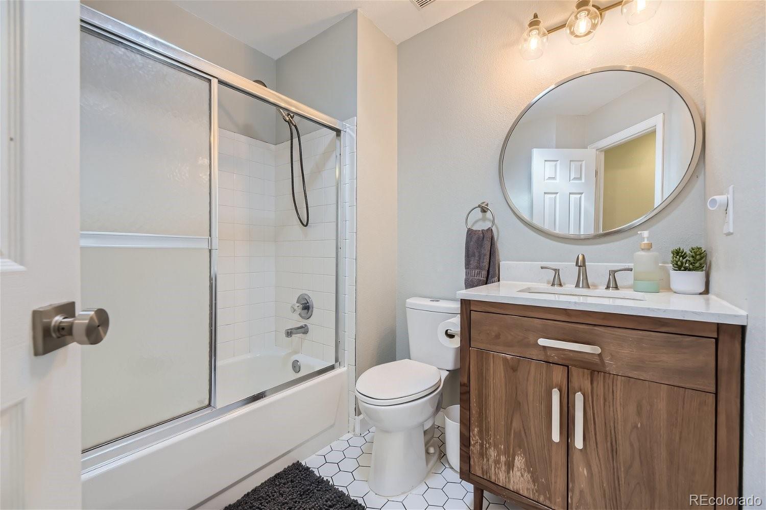 9744 South Castle Ridge Circle Highlands Ranch, CO 80129 - Photo 22 of 28 a bathroom with a toilet a sink and a mirror