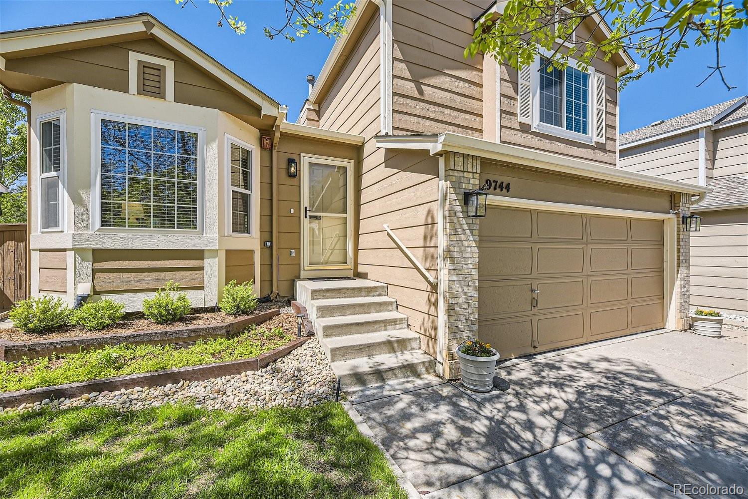 9744 South Castle Ridge Circle Highlands Ranch, CO 80129 - Photo 3 of 28 a front view of a house with a yard