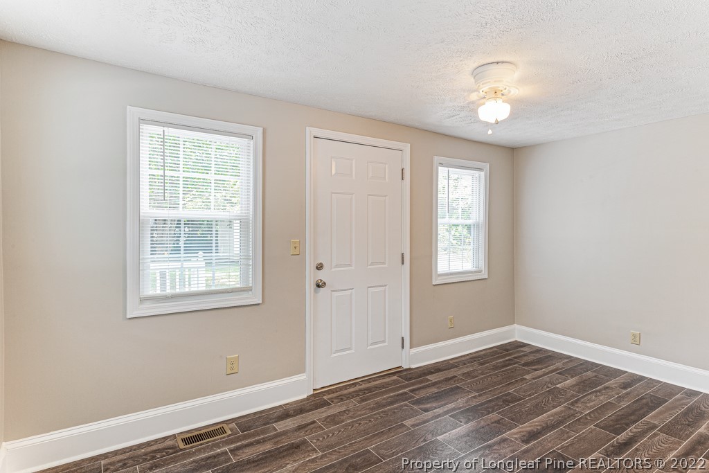 911 Anarine Road Fayetteville, NC 28303 - Photo 13 of 32 a view of an empty room with wooden floor and a window
