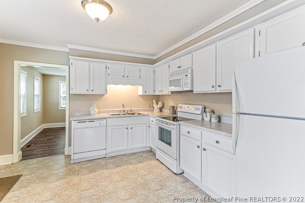 911 Anarine Road Fayetteville, NC 28303 - Photo 8 of 32 a kitchen with granite countertop white cabinets and white appliances