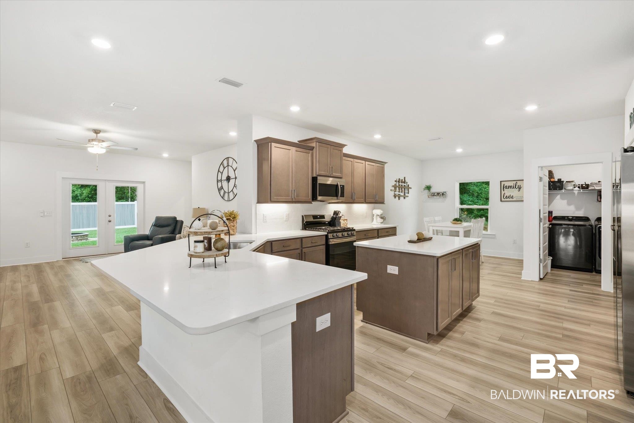 263 Bronze Street Fairhope, AL 36532 - Photo 7 of 47 Kitchen featuring washer / dryer, appliances with stainless steel finishes, a kitchen island, and light hardwood / wood-style flooring