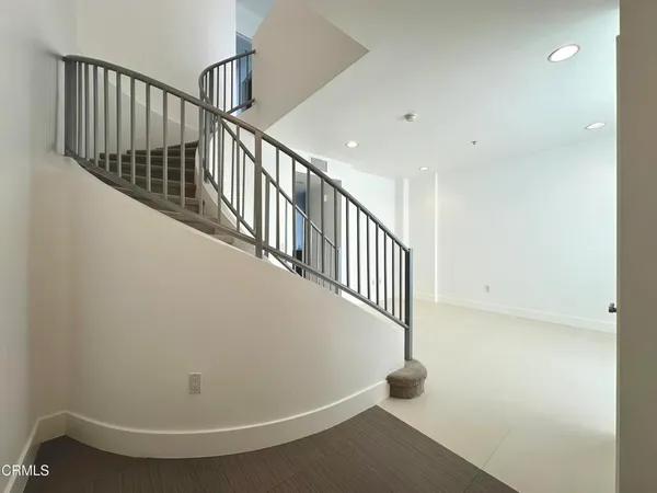 a view of staircase with railing and white walls
