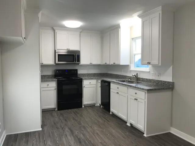 a kitchen with a stove a sink and a microwave