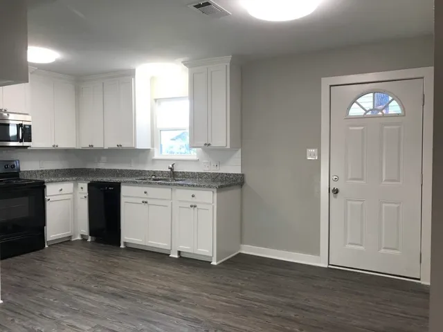 a kitchen with granite countertop stainless steel appliances a stove and a window
