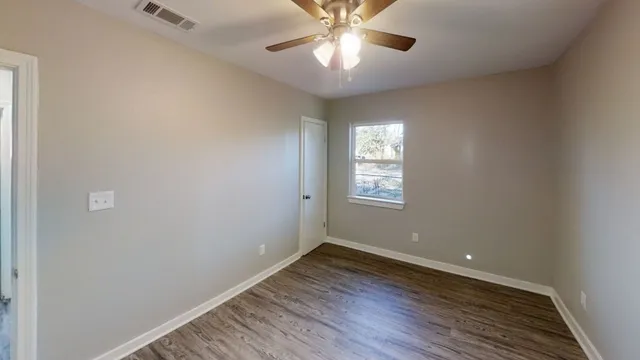 wooden floor in an empty room with a window