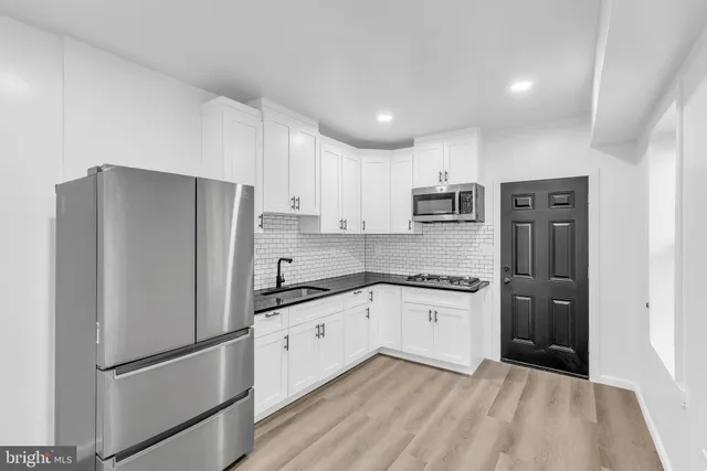 a kitchen with stainless steel appliances granite countertop a refrigerator and a stove top oven