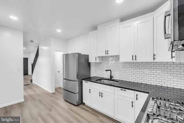a kitchen with stainless steel appliances a refrigerator sink and cabinets