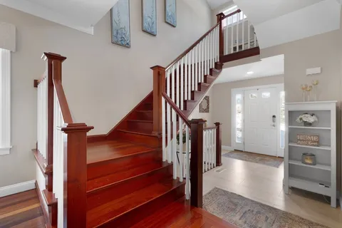 a view of hallway with stairs and wooden floor