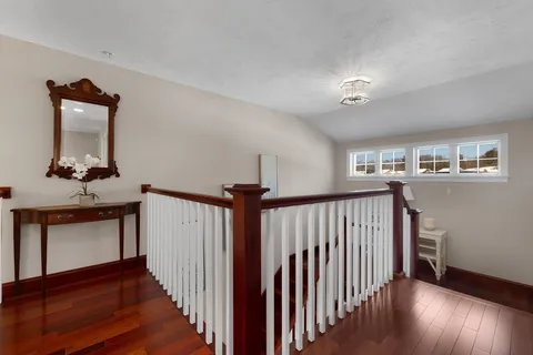a view of a hallway with wooden floor and staircase