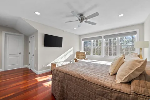 a living room with a bed furniture and a flat screen tv