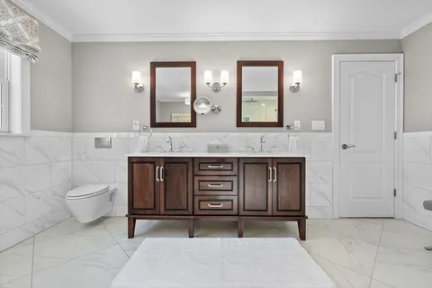 a bathroom with a granite countertop sink a toilet and mirror