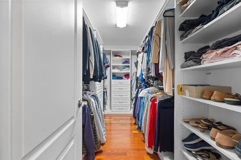 a view of walk in closet with clothes and shoes