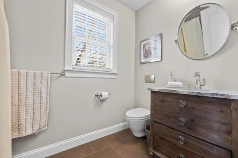 a bathroom with a toilet a sink and mirror