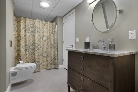 a bathroom with a sink a toilet and a mirror