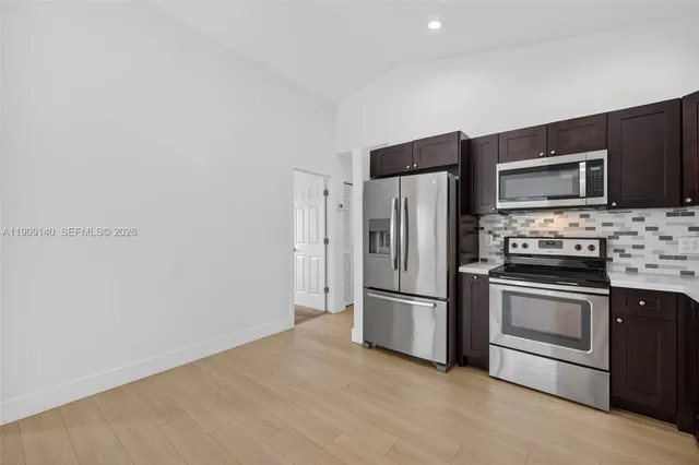 a kitchen with stainless steel appliances and a refrigerator