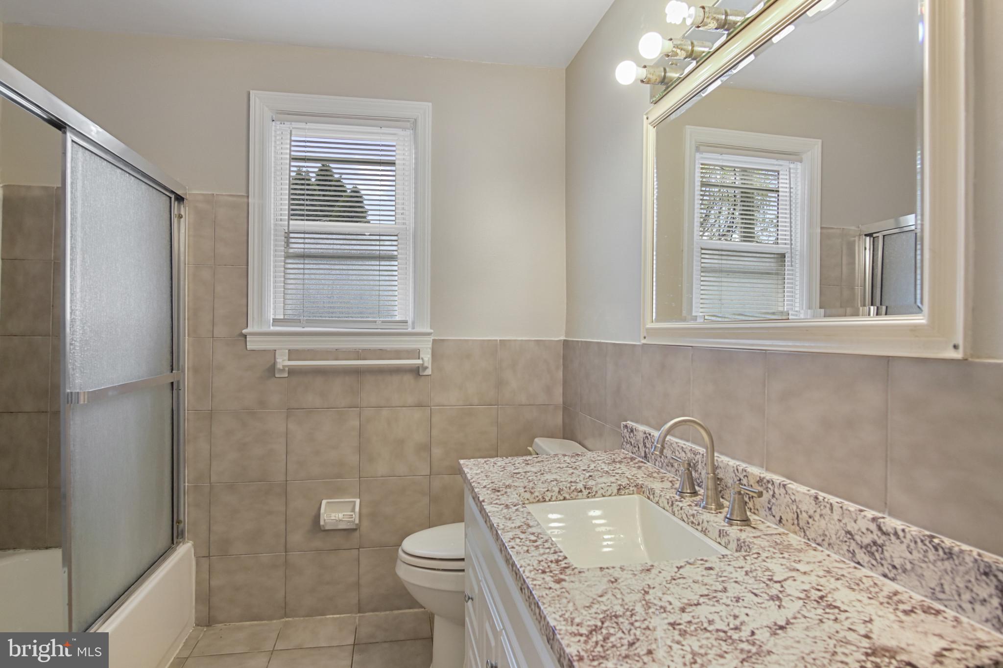 608 Farmhurst Road Baltimore, MD 21208 - Photo 36 of 45 a bathroom with a granite countertop sink toilet and shower