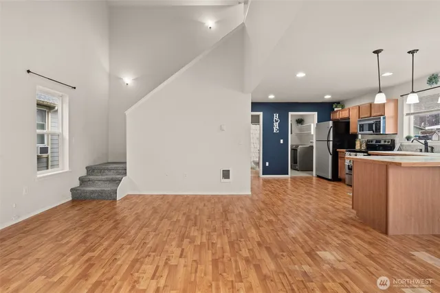 a view of a kitchen with refrigerator and wooden floor