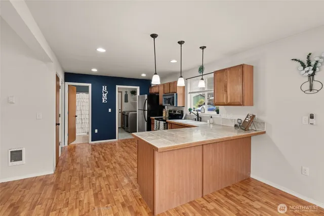 a kitchen with kitchen island a sink stainless steel appliances and cabinets