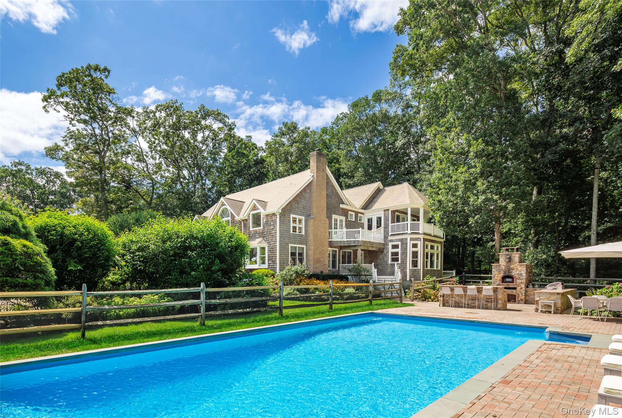 652 Noyac Path Water Mill, NY 11976 - Photo 1 of 41 View of pool featuring an outdoor stone fireplace, fence, a fenced in pool, and a patio area