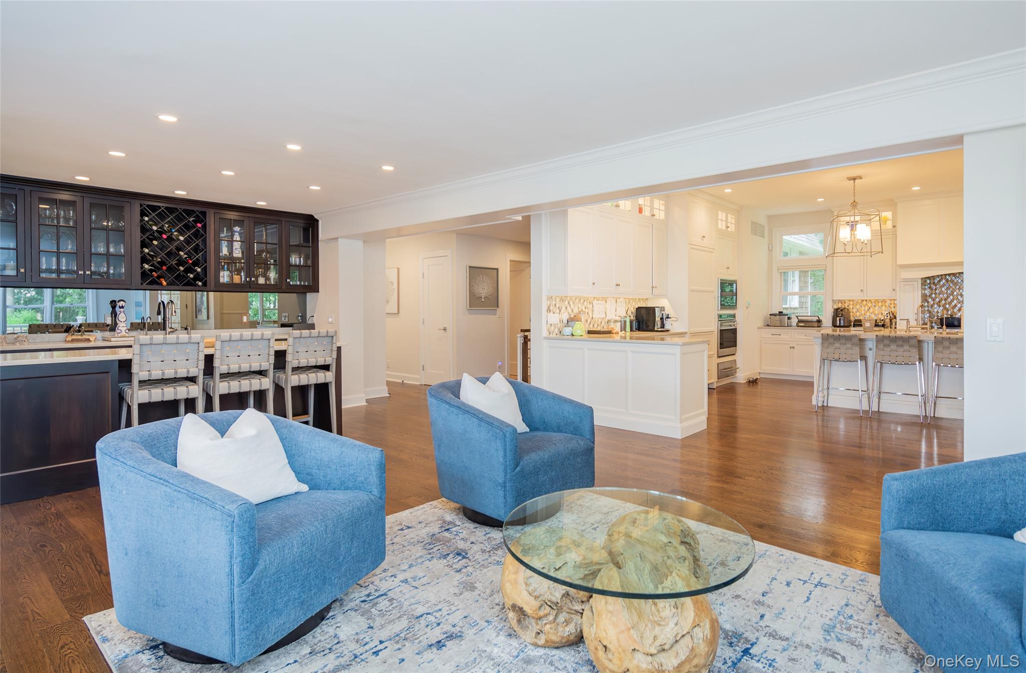 652 Noyac Path Water Mill, NY 11976 - Photo 11 of 41 Living area featuring crown molding, dark wood finished floors, indoor wet bar, recessed lighting, and an inviting chandelier