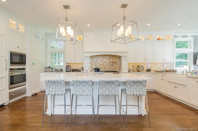 a kitchen with stainless steel appliances granite countertop wooden floor window and cabinets