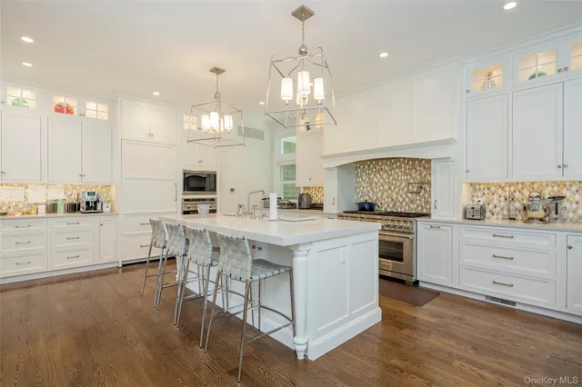 a kitchen with stainless steel appliances kitchen island granite countertop a stove a sink and a refrigerator