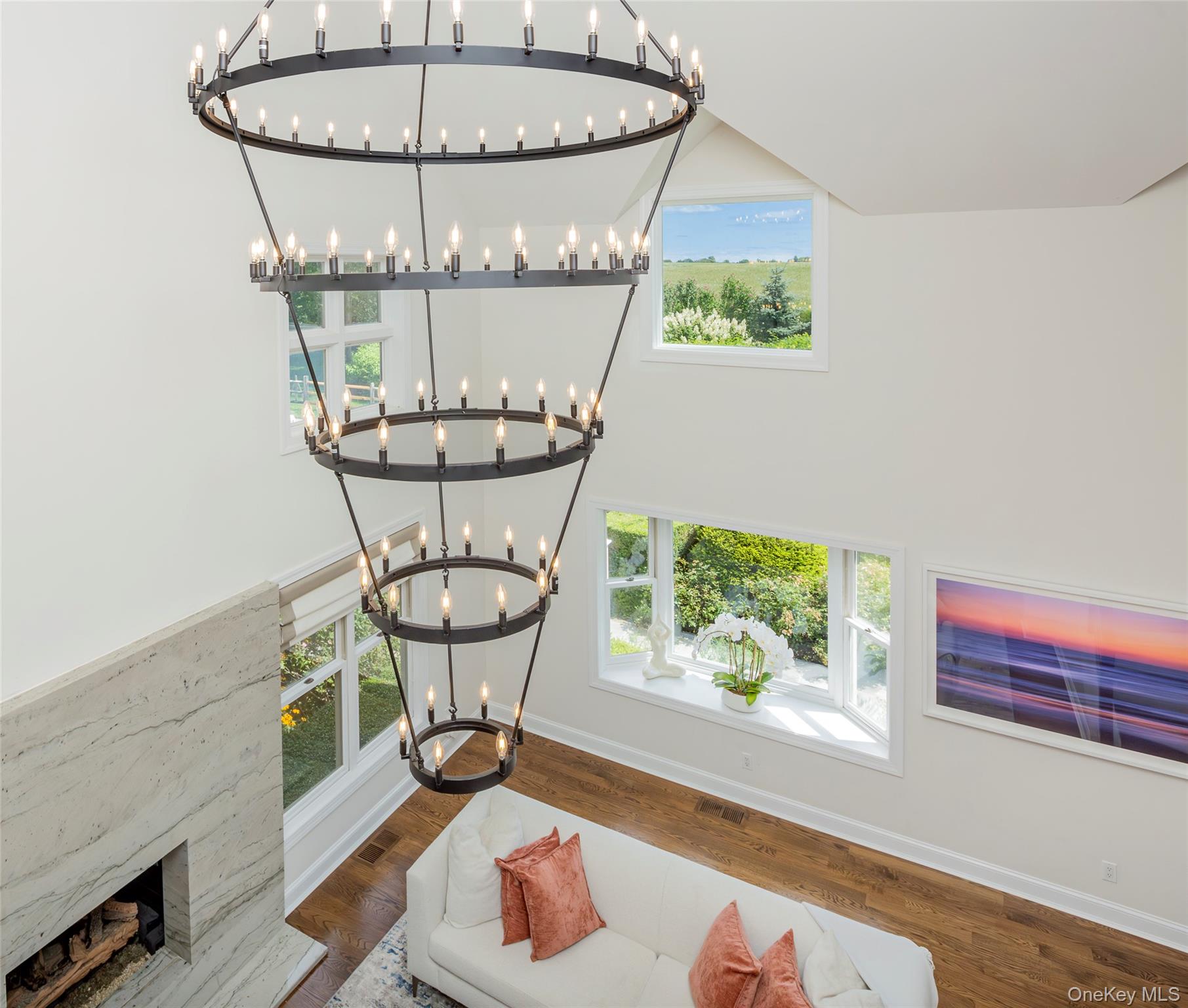 652 Noyac Path Water Mill, NY 11976 - Photo 22 of 41 Room details featuring baseboards, wood finished floors, a chandelier, and a premium fireplace