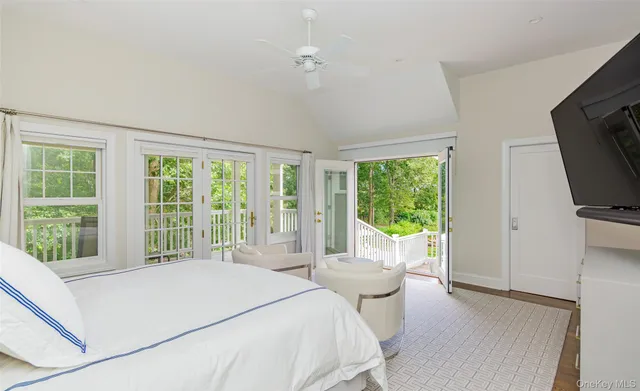 a bedroom with a large bed and a flat tv screen on dresser