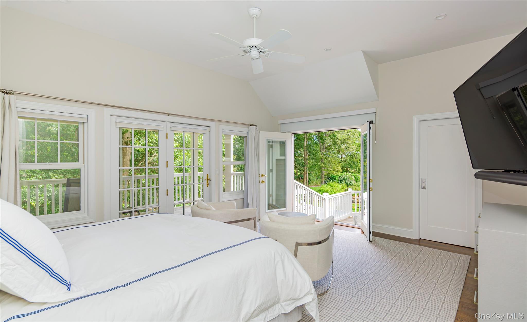 652 Noyac Path Water Mill, NY 11976 - Photo 24 of 41 Bedroom with baseboards, ceiling fan, access to outside, wood finished floors, and vaulted ceiling
