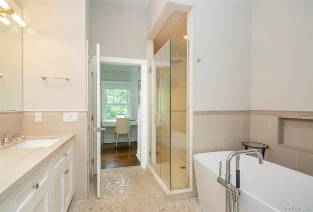 a bathroom with a tub a sink and a mirror