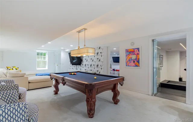 a room with furniture pool table and window