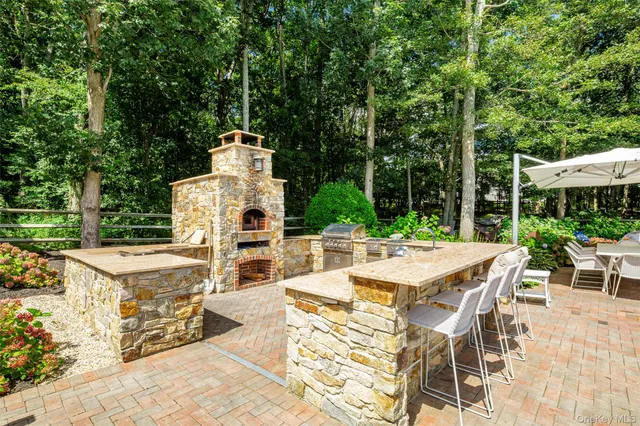 a view of a patio with table and chairs potted plants and large tree