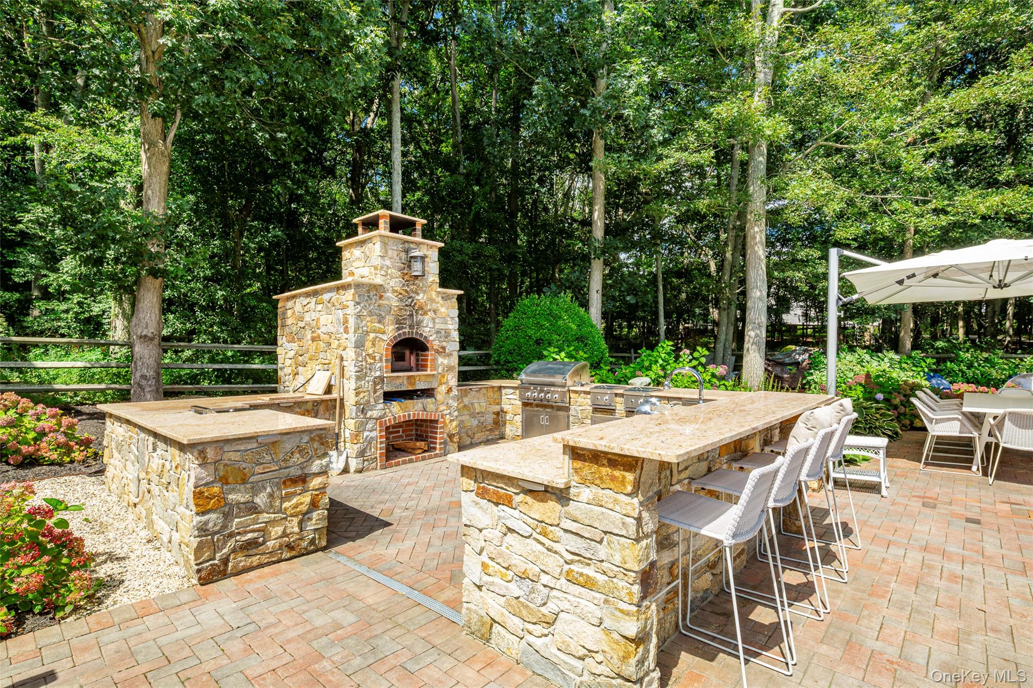 652 Noyac Path Water Mill, NY 11976 - Photo 39 of 41 View of patio / terrace with outdoor dry bar, exterior kitchen, outdoor dining space, area for grilling, and an outdoor stone fireplace
