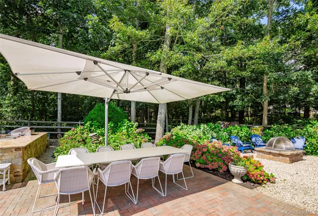 a view of a patio with table and chairs under an umbrella