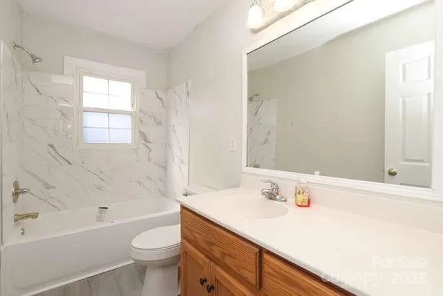 a bathroom with a sink a toilet a bathtub and shower