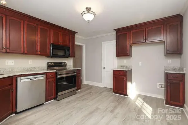 a kitchen with stainless steel appliances granite countertop wooden cabinets a stove top oven a sink and dishwasher