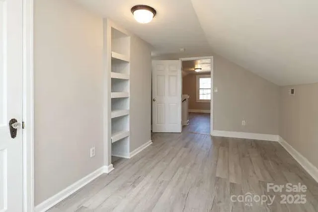 an empty room with wooden floor and closet