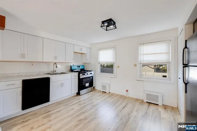 a kitchen with granite countertop a refrigerator and a stove top oven