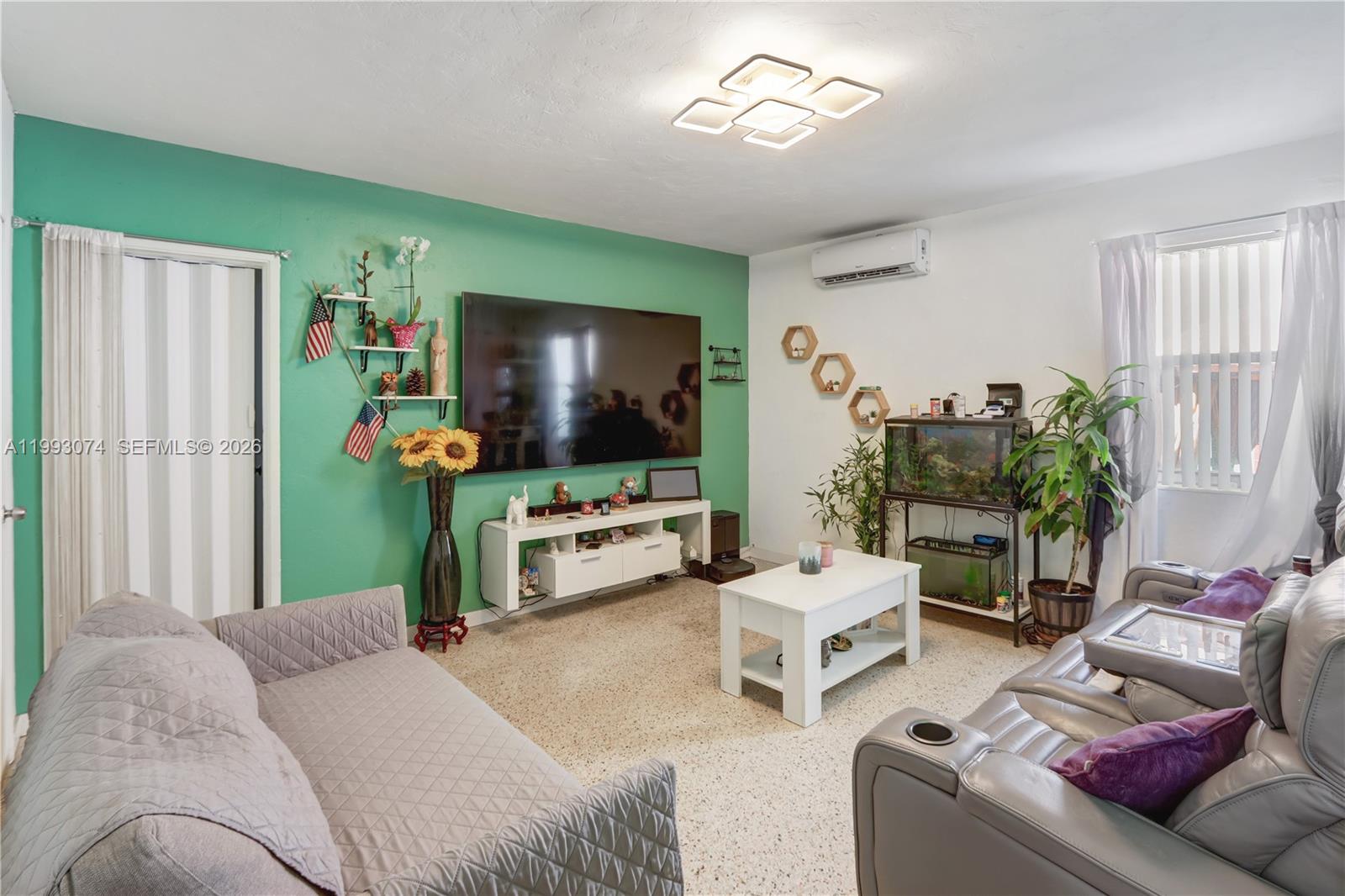 3675 Northwest 5th Street Miami, FL 33125 - Photo 4 of 8 a living room with furniture and a flat screen tv