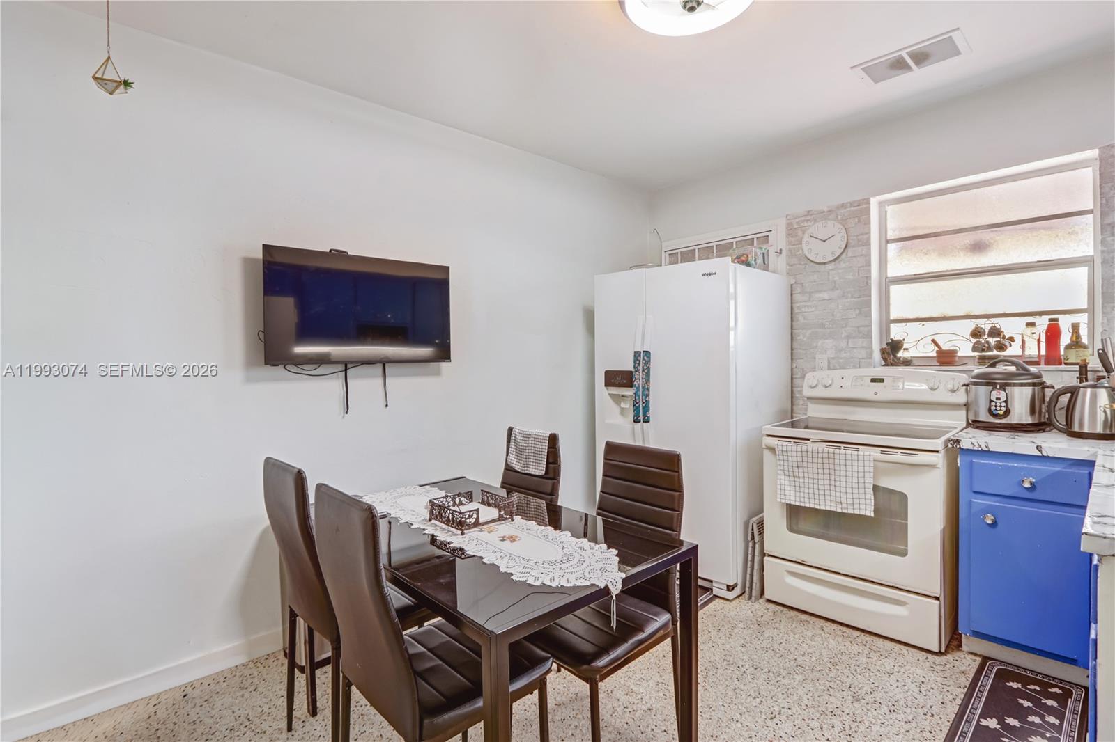 3675 Northwest 5th Street Miami, FL 33125 - Photo 8 of 8 a kitchen with stainless steel appliances a stove a refrigerator and a dining table