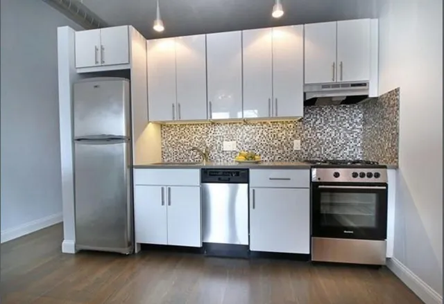 a kitchen with granite countertop white cabinets and stainless steel appliances
