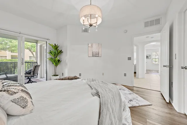 a bedroom with a large bed and a chandelier