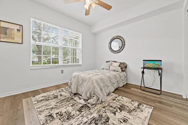 a bedroom with a bed and a window with wooden floor