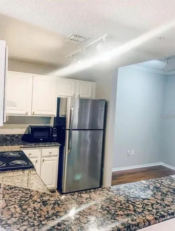 a kitchen with a refrigerator and a stove top oven