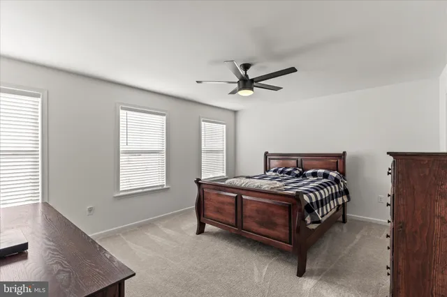 a bedroom with a bed chandelier and a window