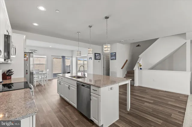 a kitchen with stainless steel appliances granite countertop a lot of counter space and wooden floor