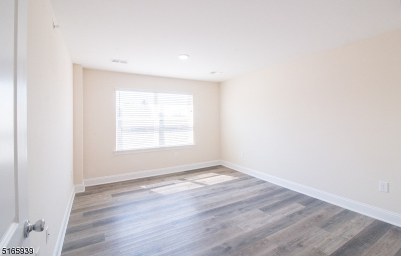 1664 Stuyvesant Avenue, Unit 306 Union, NJ 07083 - Photo 11 of 22 a view of an empty room with wooden floor and a window